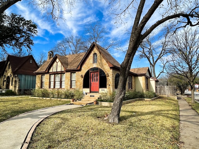 tudor home featuring a front lawn