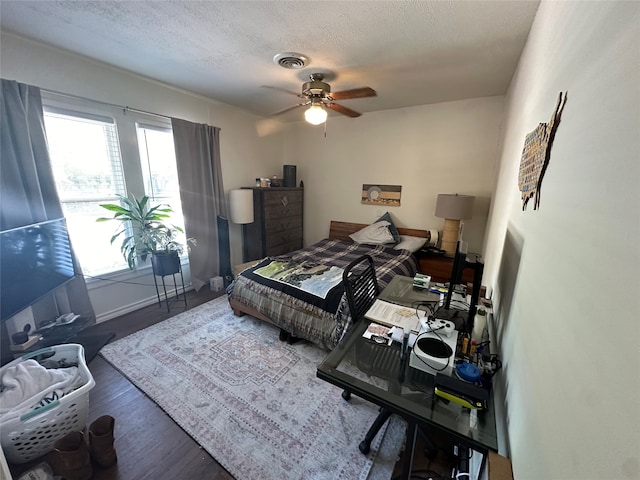 bedroom with a textured ceiling, dark hardwood / wood-style flooring, and ceiling fan