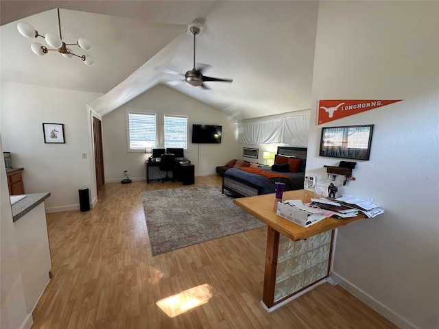 living room featuring ceiling fan with notable chandelier, light wood-type flooring, and vaulted ceiling