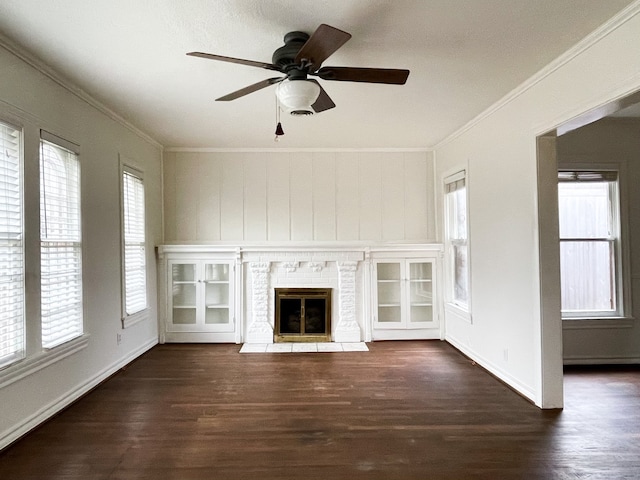 unfurnished living room featuring a wealth of natural light, ceiling fan, a fireplace, and dark hardwood / wood-style flooring