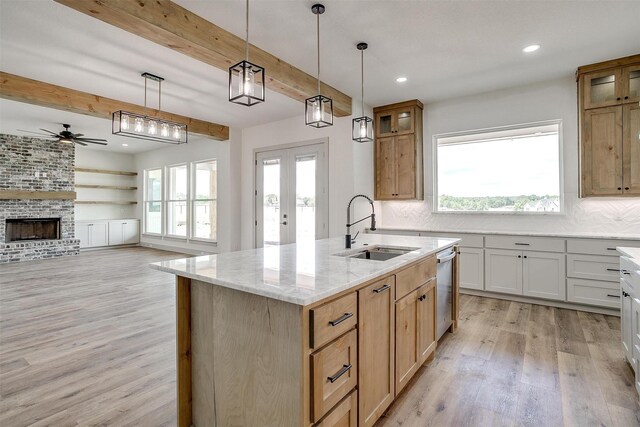 unfurnished living room with light hardwood / wood-style flooring, sink, ceiling fan, and a wealth of natural light