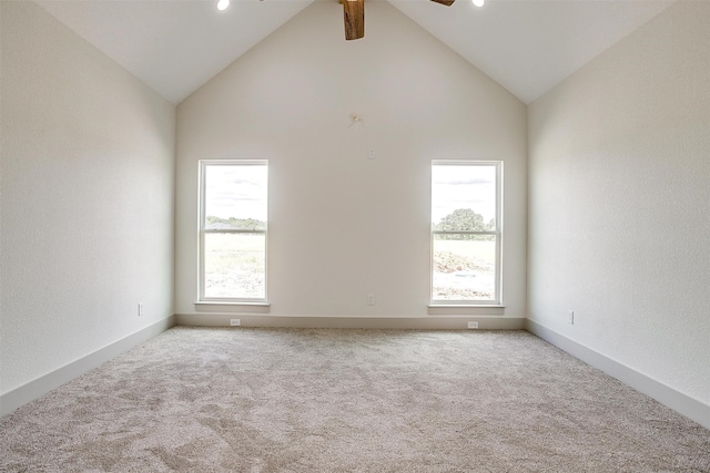 empty room featuring ceiling fan, lofted ceiling with beams, light carpet, and a healthy amount of sunlight