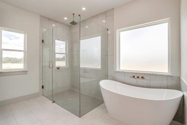 bathroom with plus walk in shower, tile patterned flooring, and tile walls