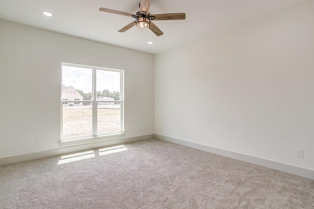 carpeted spare room with ceiling fan