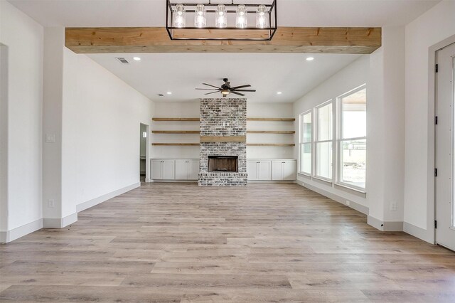 kitchen featuring light wood-type flooring, beamed ceiling, white cabinets, hanging light fixtures, and appliances with stainless steel finishes