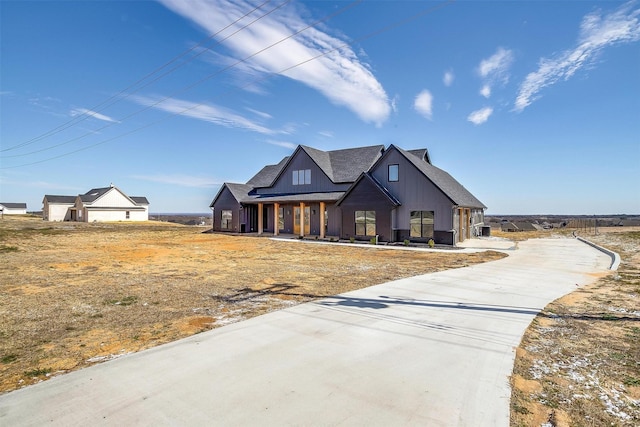 modern farmhouse style home featuring board and batten siding and roof with shingles