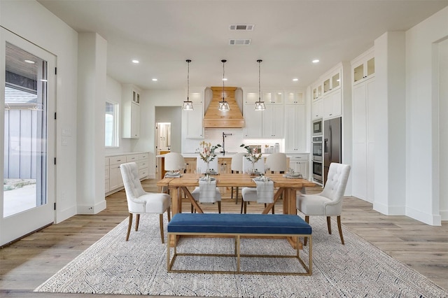 dining area with light wood-type flooring, visible vents, and recessed lighting