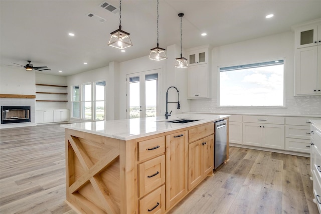 kitchen with sink, light hardwood / wood-style flooring, plenty of natural light, and a center island with sink