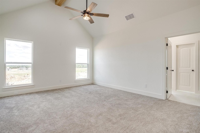 spare room featuring light colored carpet, visible vents, a ceiling fan, high vaulted ceiling, and baseboards