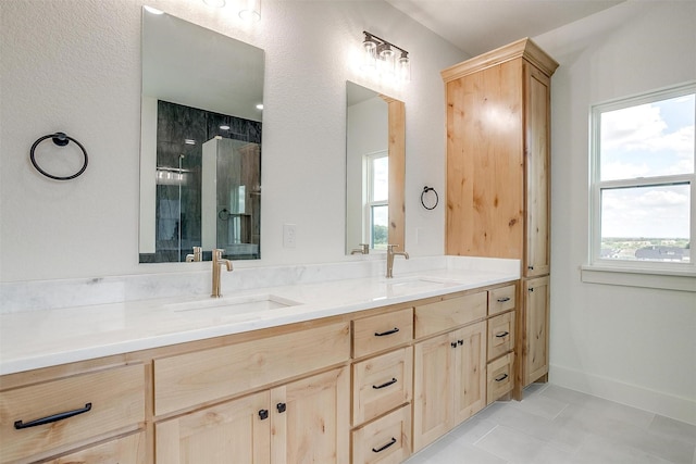 full bathroom with double vanity, baseboards, a sink, and tile patterned floors