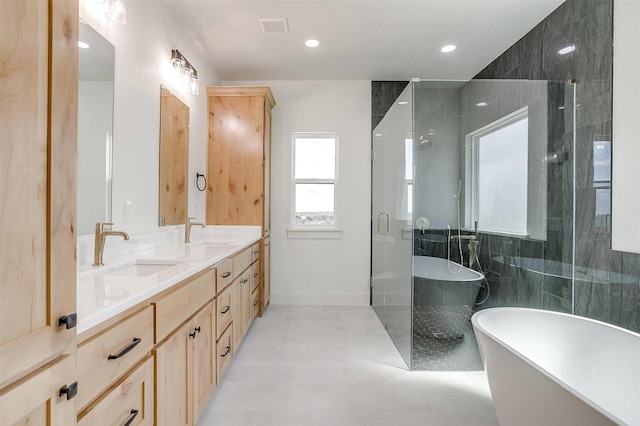 full bath with a freestanding tub, visible vents, a sink, and double vanity