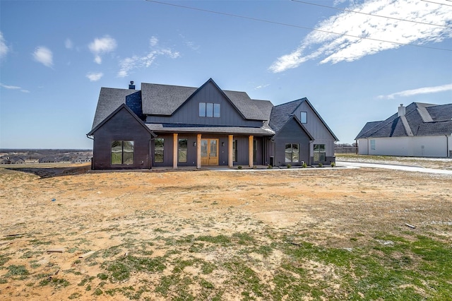 view of front of house with board and batten siding and a shingled roof