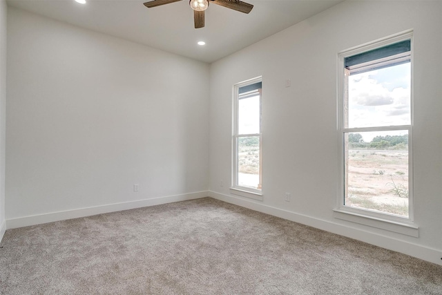 empty room featuring a ceiling fan, recessed lighting, light colored carpet, and baseboards