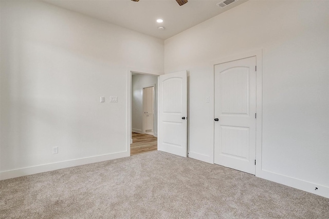 unfurnished bedroom with ceiling fan and light carpet