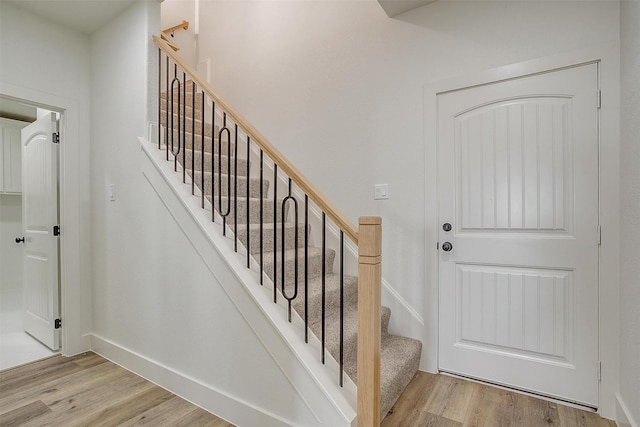 staircase with baseboards and wood finished floors