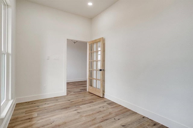 empty room featuring light wood-type flooring, baseboards, and recessed lighting