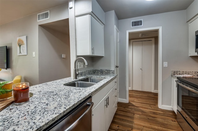 kitchen featuring appliances with stainless steel finishes, sink, white cabinets, and dark hardwood / wood-style flooring