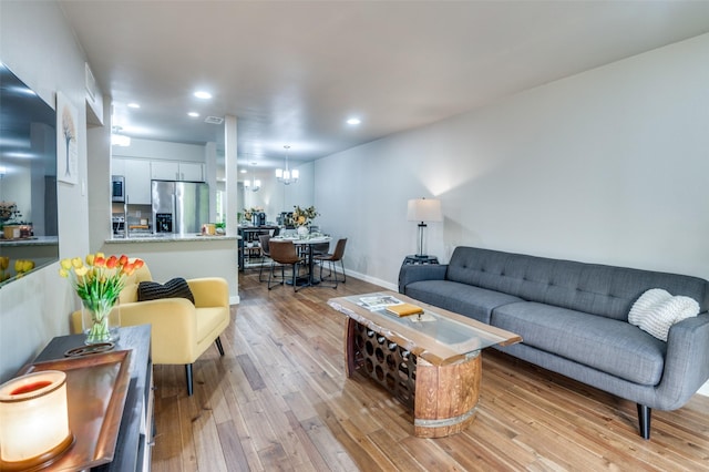 living room with an inviting chandelier and light hardwood / wood-style floors