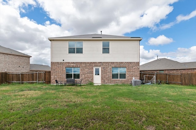 rear view of house featuring a yard and central AC