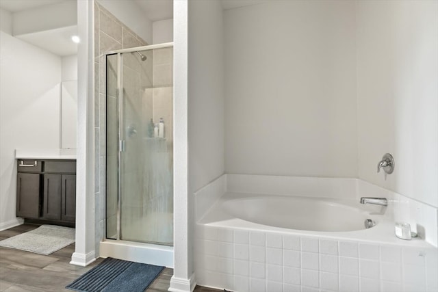 bathroom featuring wood-type flooring and separate shower and tub