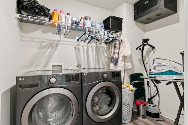 washroom featuring washing machine and clothes dryer and hardwood / wood-style flooring