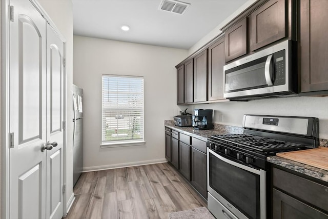 kitchen featuring light hardwood / wood-style flooring, stainless steel appliances, wood counters, and dark brown cabinetry