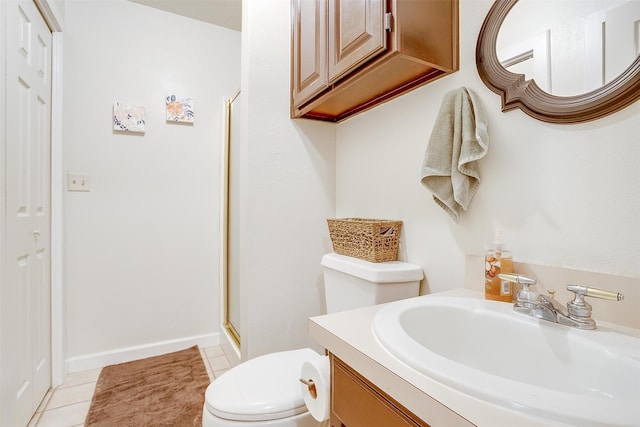 bathroom with vanity, toilet, tile patterned floors, and a shower with door