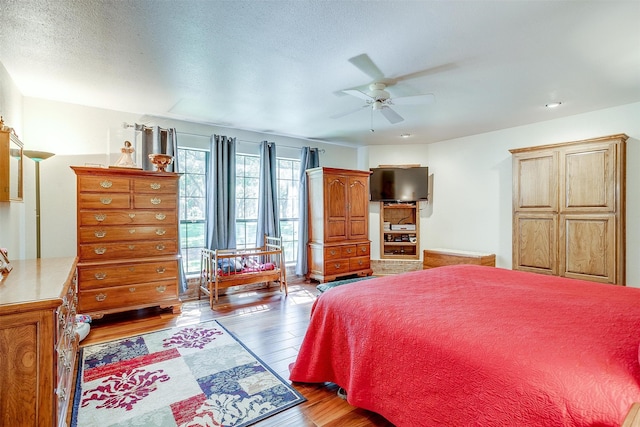 bedroom featuring a textured ceiling, ceiling fan, and wood-type flooring