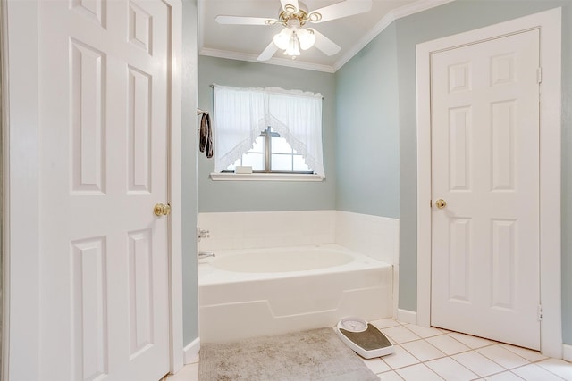 bathroom with tile patterned flooring, crown molding, ceiling fan, and a bathtub