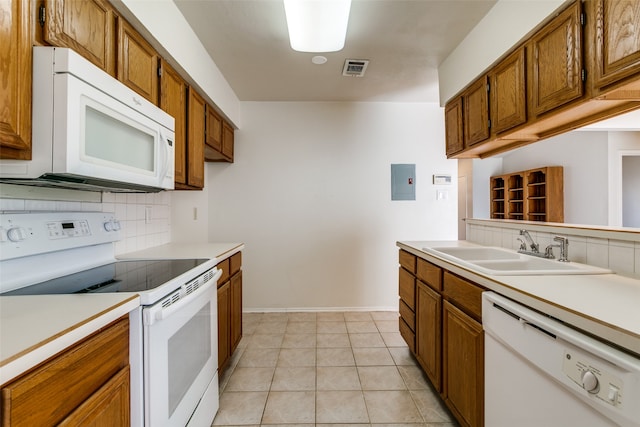 kitchen featuring backsplash, light tile patterned floors, white appliances, electric panel, and sink