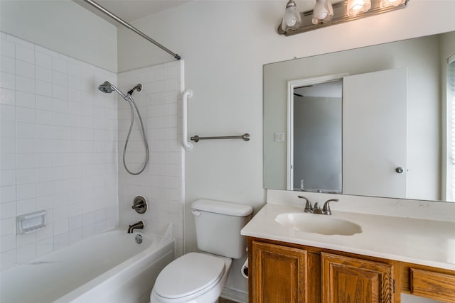 full bathroom featuring tiled shower / bath combo, vanity, and toilet