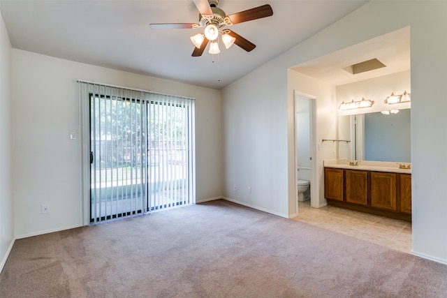 unfurnished bedroom featuring ceiling fan, ensuite bathroom, light carpet, and access to exterior