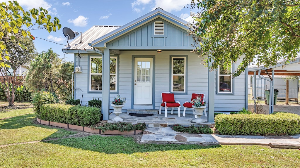 bungalow-style home featuring a front yard and a carport