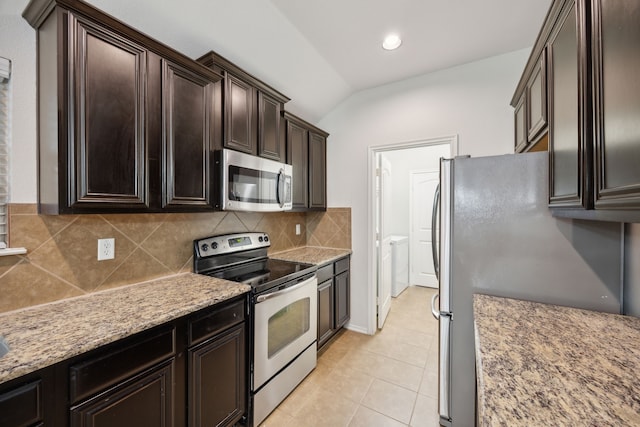 kitchen with lofted ceiling, backsplash, light tile patterned floors, light stone counters, and stainless steel appliances