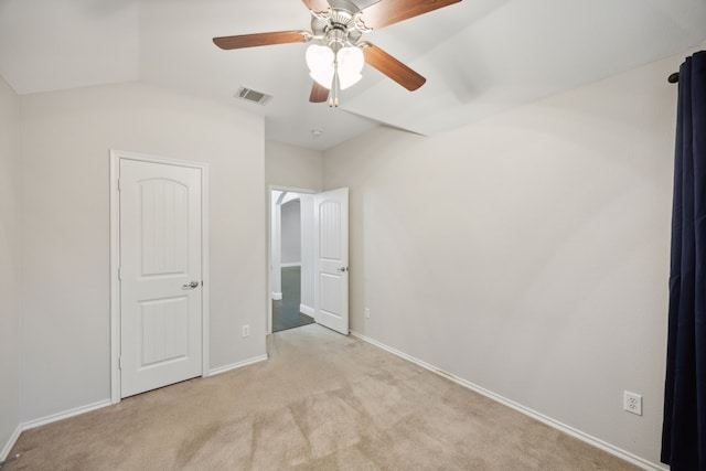 unfurnished bedroom featuring ceiling fan, light carpet, and vaulted ceiling