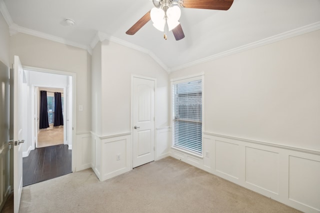 unfurnished bedroom featuring ceiling fan, crown molding, vaulted ceiling, light carpet, and a closet