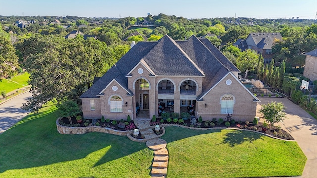 view of front of house with a balcony and a front lawn