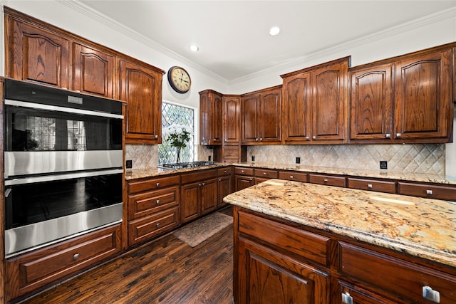 kitchen with light stone counters, dark hardwood / wood-style flooring, crown molding, decorative backsplash, and appliances with stainless steel finishes