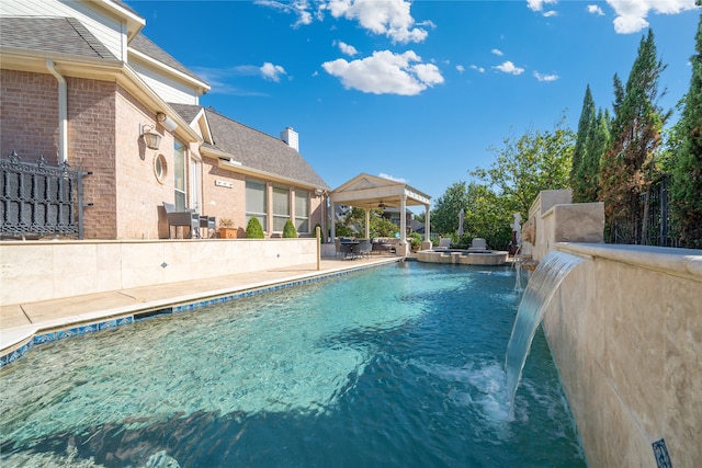 view of swimming pool with pool water feature, ceiling fan, and a patio