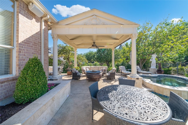 view of patio / terrace with outdoor lounge area, ceiling fan, and an in ground hot tub