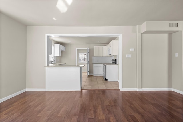 unfurnished living room with sink and light hardwood / wood-style flooring