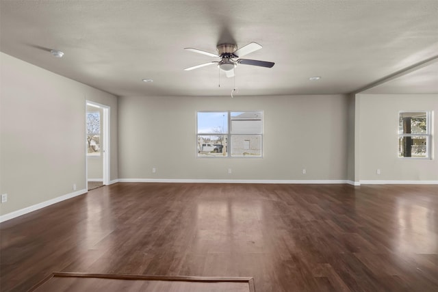 empty room featuring dark wood-type flooring and ceiling fan