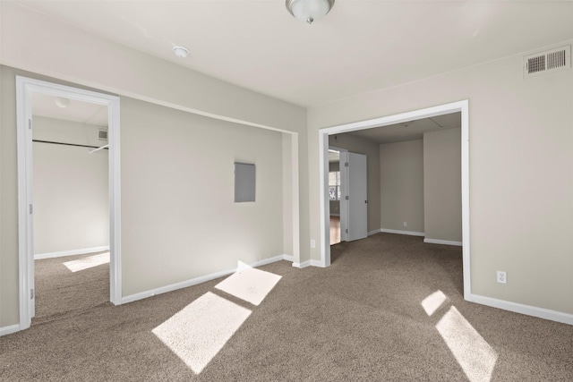 unfurnished bedroom featuring a spacious closet, a closet, and carpet flooring