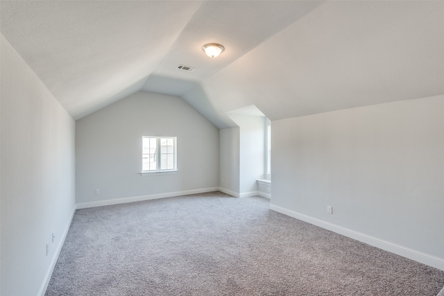 bonus room featuring light carpet and vaulted ceiling