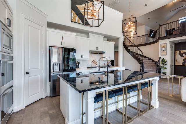 kitchen with light wood-type flooring, decorative light fixtures, appliances with stainless steel finishes, and a chandelier