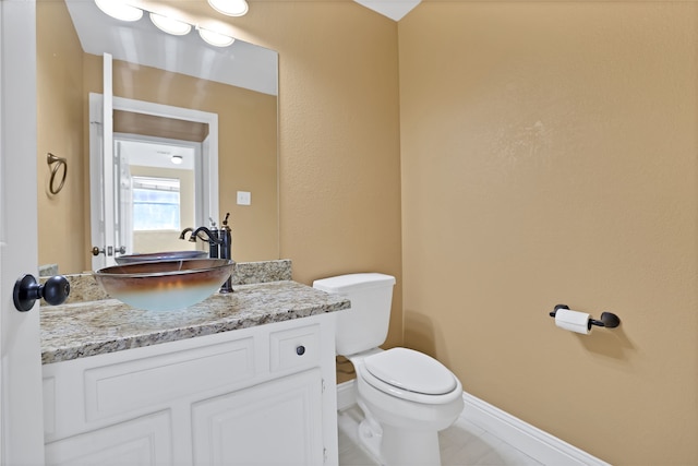 bathroom featuring vanity, tile patterned flooring, and toilet