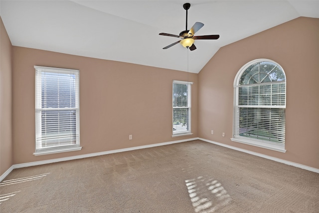 spare room with a healthy amount of sunlight, carpet flooring, vaulted ceiling, and ceiling fan