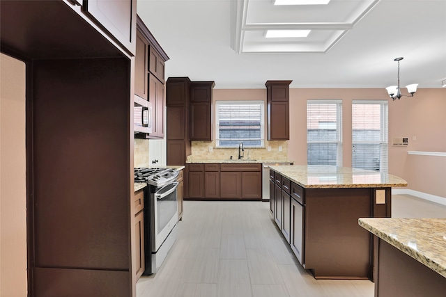 kitchen with light stone counters, tasteful backsplash, stainless steel appliances, decorative light fixtures, and sink