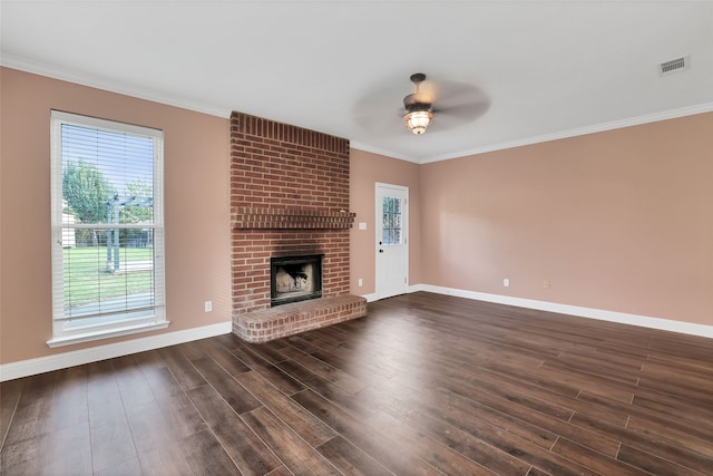 unfurnished living room featuring a brick fireplace, ceiling fan, crown molding, and dark hardwood / wood-style flooring