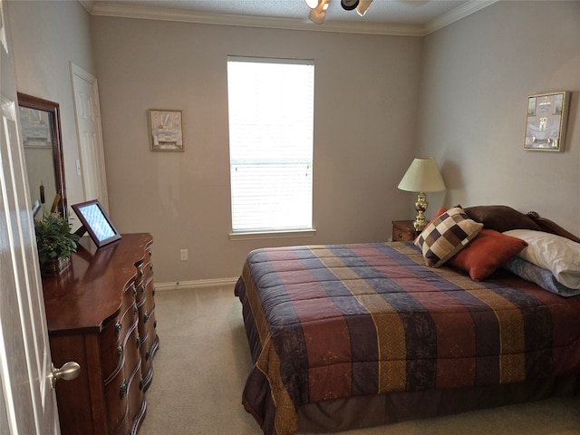 carpeted bedroom with ornamental molding and ceiling fan